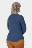 Back view of a woman wearing the Dovetail Workwear Honed Long Sleeve Thermal Henley in Atlantic Blue with Kodiak Brown pants, showcasing the reinforced elbows and waffle knit thermal base layer.
