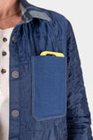 Detail shot of the Durham Reversible Quilted Shirt Jac by Dovetail Workwear in Loden Green Plaid or Barn Red Plaid, highlighting the canvas pocket with item inside