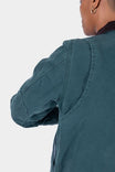 Back view of a woman wearing the Dovetail Workwear Old School Trucker Canvas Work Jacket in Lodge Green, highlighting the bi-swing back pleats and heavy-duty duck canvas construction