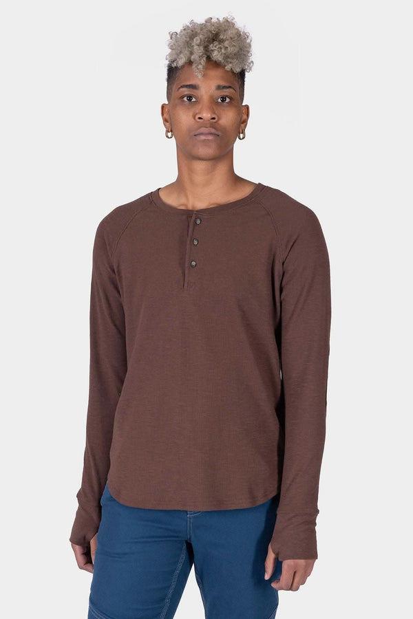 Kodiak Brown Honed Long Sleeve Thermal Henley by Dovetail Workwear worn by a woman, featuring waffle knit fabric, button front placket, reinforced elbows, and thumbholes, paired with blue jeans