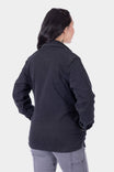Back view of a woman wearing the Dovetail Workwear Oahe HOTSWAP™ Thermal Denim Work Jacket in Black, showing the reinforced elbows and relaxed fit design