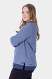 Back view of a woman wearing the Dovetail Workwear GO TO™ Crew Sweatshirt in Slate Blue/Atlantic Blue, showing the relaxed fit and Dovetail graphic at the hem
