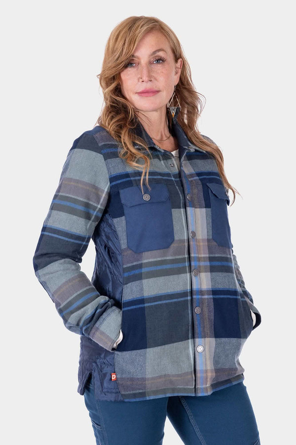 Woman wearing the Durham Reversible Quilted Shirt Jac by Dovetail Workwear in Loden Green Plaid or Barn Red Plaid, featuring quilted insulation and reinforced shoulders, with one hand in pocket