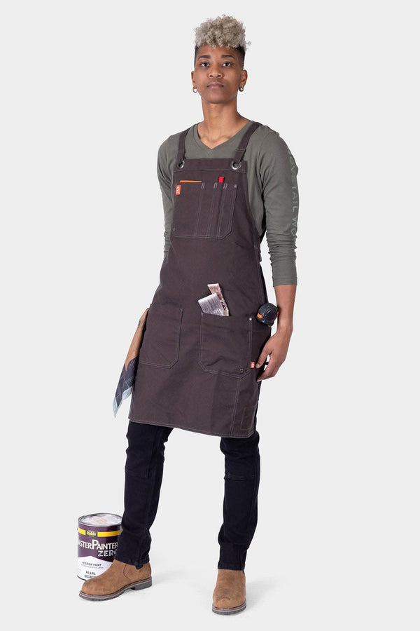 Dovetail Workwear Obana Work Apron in Kodiak Brown worn by a woman with cross-back straps, 8 pockets, and tool storage displayed against a white background