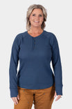 Dovetail Workwear's Honed Long Sleeve Thermal Henley in Atlantic Blue, shown on a woman wearing caramel pants, featuring a button placket and reinforced elbows