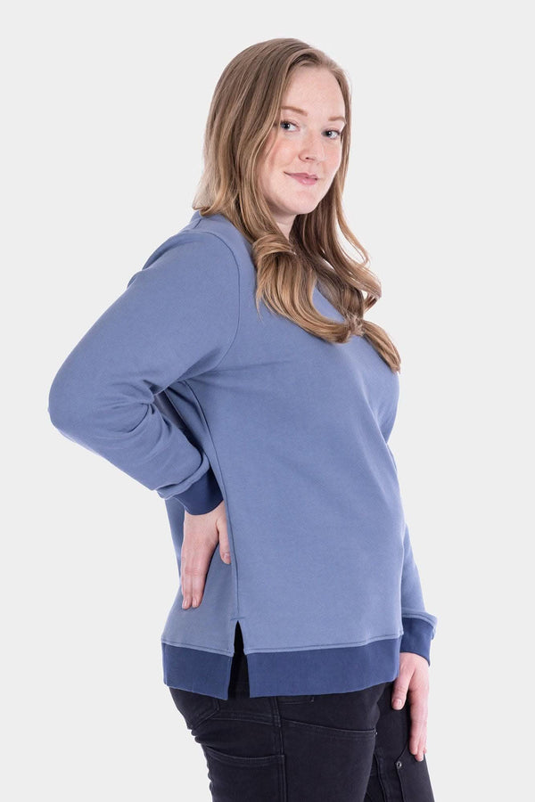 Back view of a woman wearing the Dovetail Workwear GO TO™ Crew Sweatshirt in Slate Blue/Atlantic Blue, featuring a relaxed fit and midweight fleece construction