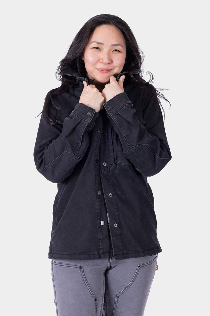 Black Oahe HOTSWAP™ Thermal Denim Work Jacket by Dovetail Workwear shown on a woman, featuring wind-resistant HotSwap™ stretch denim with reinforced elbows and multiple pockets