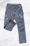 Flat lay of Dovetail Workwear's Britt Utility HOTSWAP™ Pant in Grey Thermal Denim, displaying cargo-style pockets, tool loop, and thermal fabric with paint splatters from work use