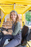 Woman seated in a yellow vehicle wearing the Carver Wool Wild Rag Bandana in Navy, tied around her neck
