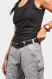 Woman wearing Dovetail Workwear's Flex Work Belt in black, featuring a double-pronged buckle and elastic back panel, paired with gray cargo pants