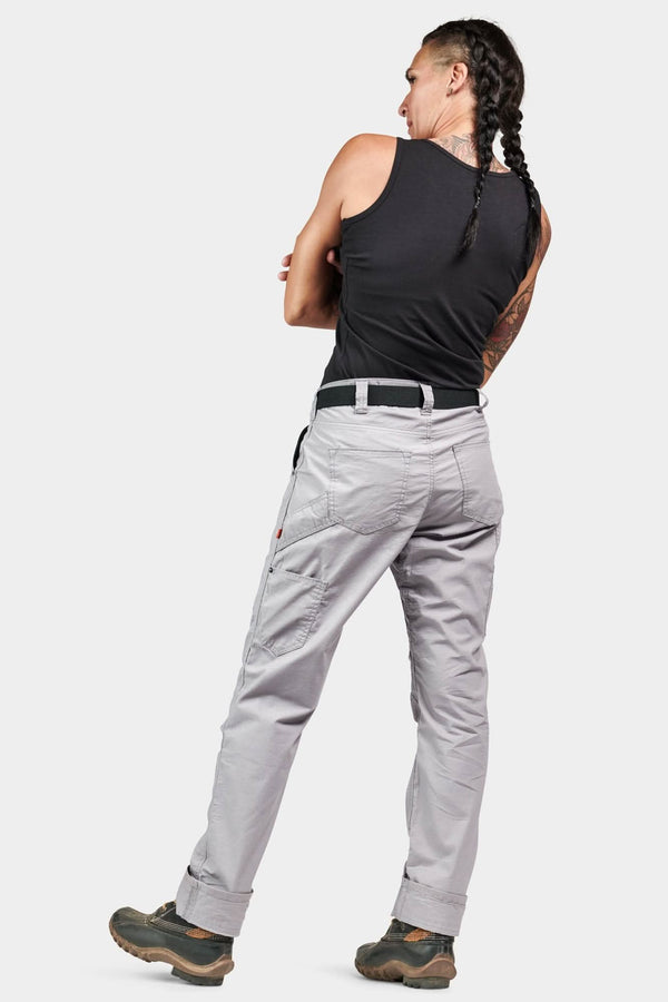 Back view of a woman wearing Dovetail Workwear's Anna Ultralight Trail Pant in Dove Grey Ripstop with Reinforced Knees and Hip Slot™ Tool Loop, paired with a black tank top
