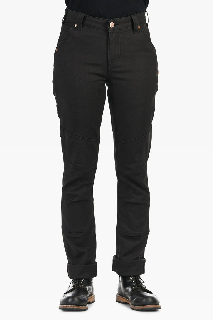 Woman wearing Dovetail Workwear GO TO™ Stretch Canvas Pant in Carbon Black, showing the straight leg silhouette with articulated knee panels and reinforced knees, paired with black lace-up boots