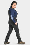 Back view of a woman wearing Dovetail Workwear Freshley Drop Seat Overalls in Black Stretch Thermal Denim with Reinforced Knees and nested pockets