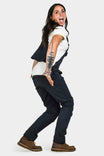 Back view of a woman wearing Dovetail Workwear's Freshley Drop Seat Overalls in Navy Canvas, showcasing the hidden zip drop seat feature and reinforced knees.