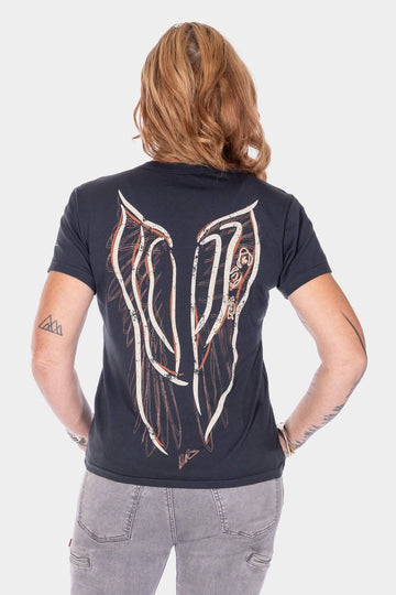 Back view of a woman wearing the Rae Ripple x Dovetail Workwear Brave Wings T-Shirt in black, showcasing the signature winged artwork and "The universe always listens to the brave" design across the back.