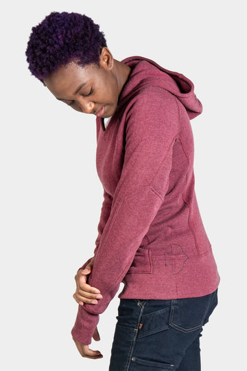 Side view of a woman wearing the Dovetail Blue Anna Pullover Hoodie by Dovetail Workwear, showing the fitted silhouette, reinforced elbows, and front handwarmer pocket