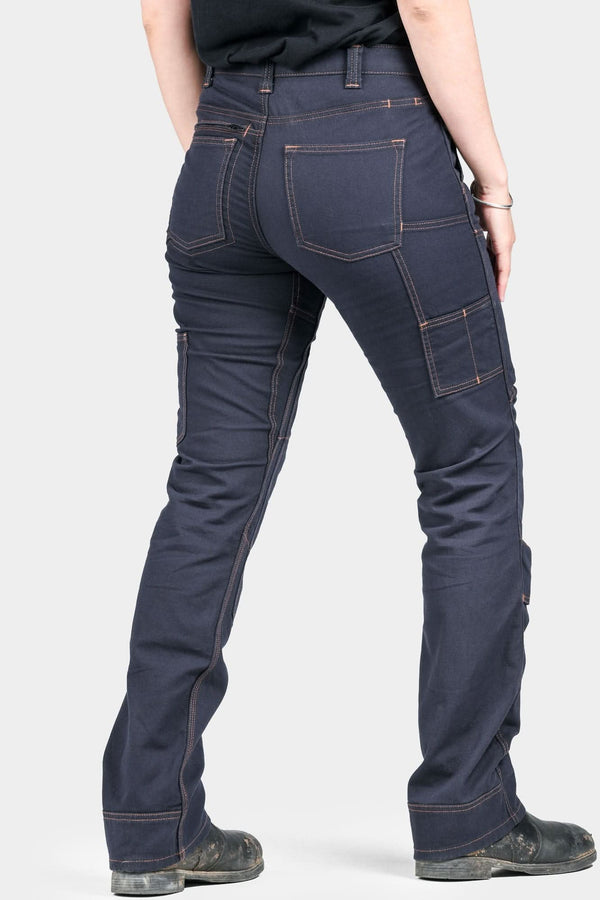 Back view of a woman wearing Dovetail Workwear's Britt Utility Pant in FR Navy Canvas, featuring cargo-style pockets, reinforced knees, and straight leg fit