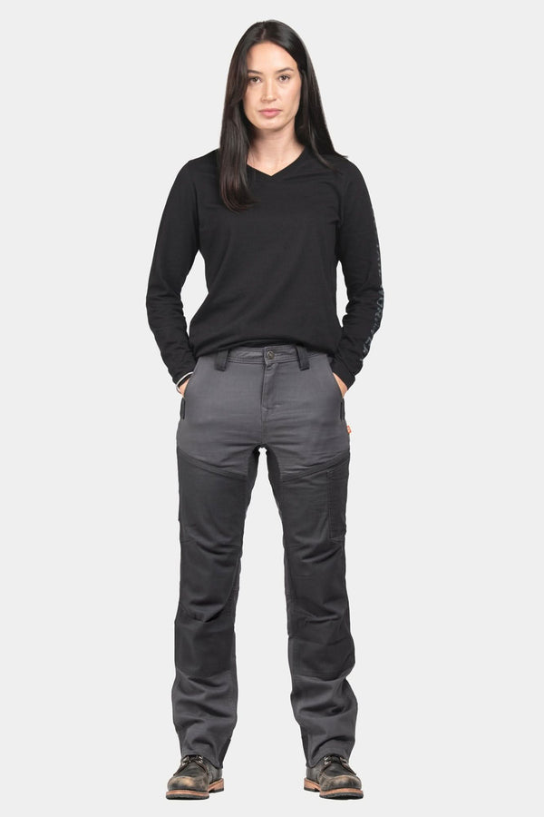 Dovetail Workwear D-Fender Pant in Cement Grey shown on a woman wearing a black long-sleeve v-neck shirt, displaying the straight leg design with reinforced knees and crotch gusset