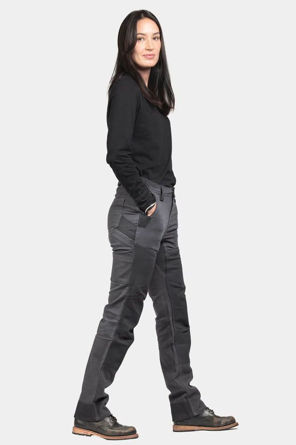 Side view of a woman wearing Dovetail Workwear's D-Fender Pant in Cement Grey Stretch Canvas with reinforced knees and straight leg fit