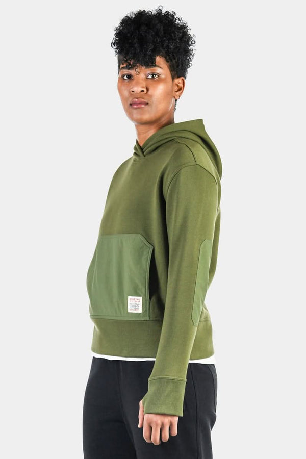Back view of a woman wearing the Moss Green Flagger Fleece Hoodie by Dovetail Workwear, featuring reinforced nylon elbow and front pocket overlays with thumbhole cuffs