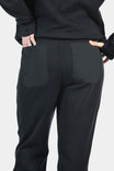 Back view of a woman wearing the Flagger Fleece Jogger Work Pant in Black, showing reinforced back pockets and relaxed tapered leg fit