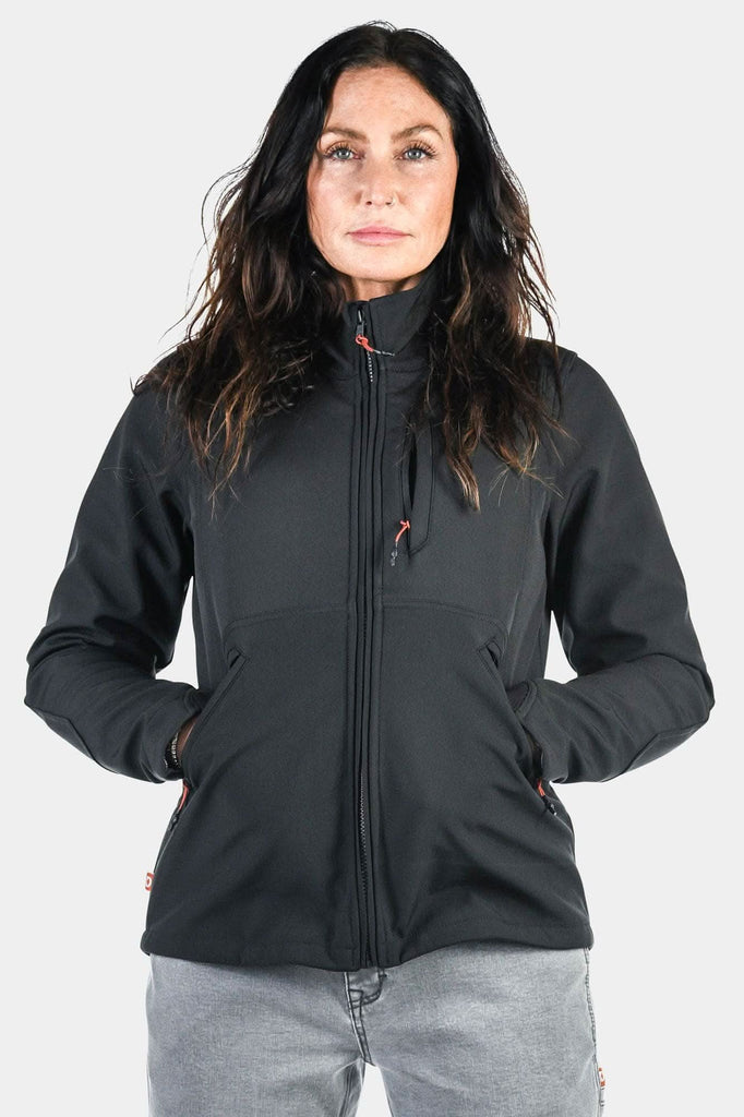 M'fon Jacket in Black by Dovetail Workwear displayed on a woman with hands in pockets, showing the water-resistant softshell exterior and high collar design