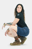 Back view of a woman wearing Dovetail Workwear's Wabash Work Short in Wabash Stripe, featuring an 8-inch inseam with frayed cuff and Hip Slot™ tool loop detail