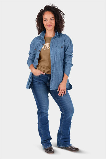 Woman wearing the John Deere X Dovetail Cultivator Work Shirt in Indigo Blue Dobby over a tan graphic tee, paired with dark blue jeans
