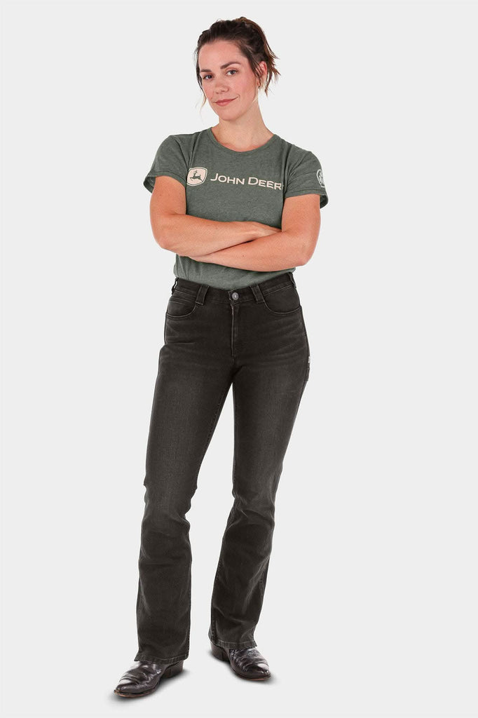 Woman wearing John Deere X Dovetail Workwear Into Town Bootcut Jeans in Classic Black with arms crossed, featuring mid-rise fit and bootcut leg