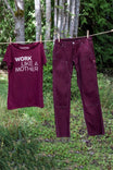 Elderberry Dovetail Workwear Anna Taskpant canvas work pants hung on a clothesline, displayed alongside a matching maroon graphic tee
