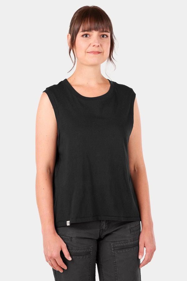 Black Bellows Work Tank Top by Dovetail Workwear worn by a woman, featuring a loose-fit design with breathable cotton fabric and a back pleat