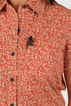 Close-up detail of the Dovetail Workwear Carver Work Shirt in Paprika, showcasing the paisley print, dark button closures, and chest pocket design on a woman