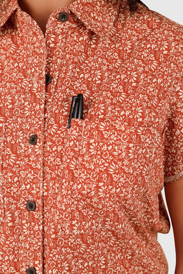 Close-up detail of the Dovetail Workwear Carver Work Shirt in Paprika, showcasing the paisley print, dark button closures, and chest pocket design on a woman