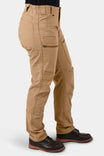 Side view of a woman wearing Dovetail Workwear's Provisions Lightweight Ripstop Cargo Pant in Tan Sandstone, featuring multiple cargo pockets and a relaxed leg fit