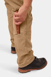 Detail shot of Dovetail Workwear Provisions Lightweight Ripstop Cargo Pant in Tan Sandstone, showing woman holding tool with visible cargo pocket and crotch gusset design