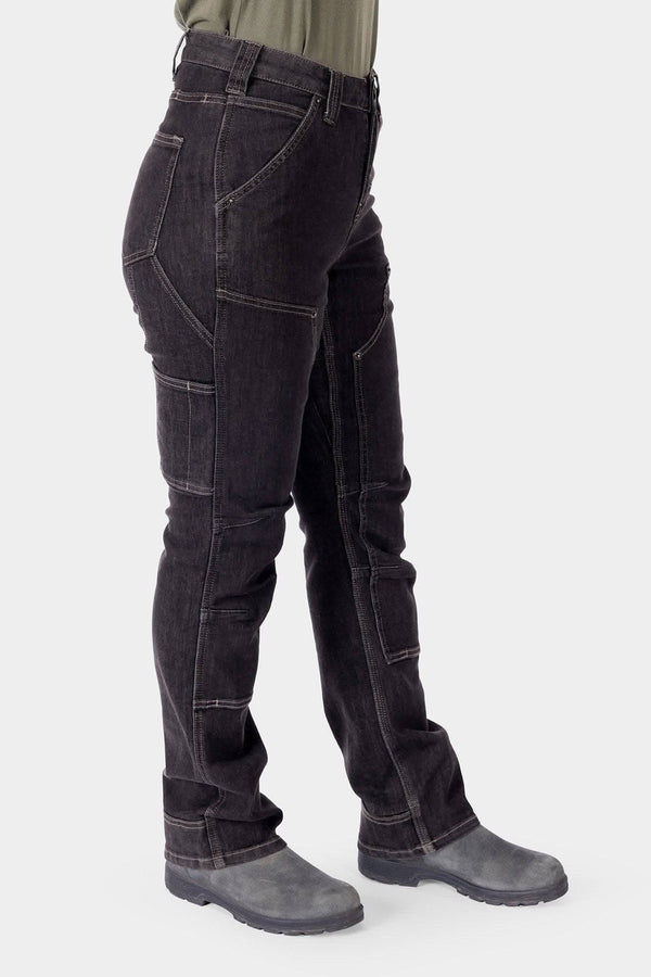 Side view of a woman wearing Dovetail Workwear's Old School High Rise Graphene Denim Pant in Heather Black, featuring visible cargo pockets, knee pad slots, and crotch gusset detail