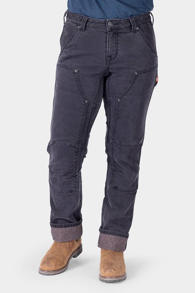 Britt Utility HOTSWAP™ Pant in Black Thermal Denim by Dovetail Workwear, shown on a woman wearing tan boots, featuring cargo-style pockets and Tough Cuff™ rolled cuffs