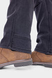 Detail view of the Britt Utility HOTSWAP™ Pant in Black Thermal Denim by Dovetail Workwear, showing the calf and boot, highlighting the durable denim fabric and rugged construction