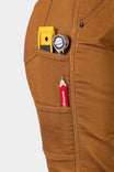 Detail shot of Dovetail Workwear's Britt Utility HOTSWAP™ Pant in Saddle Brown Thermal Denim showing functional cargo pocket with yellow whistle, measuring tape, and red pencil