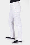 Side view of a woman wearing the GO TO™ Stretch Canvas Work Pant in Painter's White by Dovetail Workwear, showcasing the articulated knee and nested pockets with black slip-on sneakers