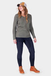 Woman wearing Dovetail Workwear Field Utility Legging in Black with gray long-sleeve top and brown work boots, looking to the side