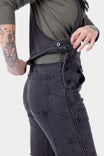 Detail view of the hidden zip drop seat feature on Dovetail Workwear's Freshley HOTSWAP™ Drop Seat Thermal Denim Overalls in Black, demonstrated by a woman opening the overalls
