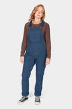Atlantic Blue GO TO™ Stretch Canvas Overalls by Dovetail Workwear worn with a brown long-sleeve shirt and black sneakers, shown full length on a woman