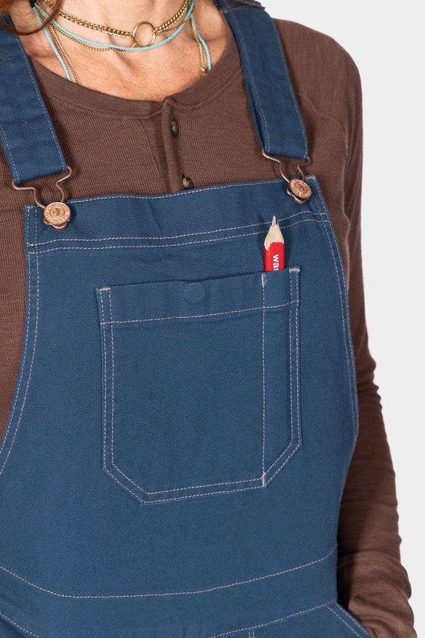 Detail of the Atlantic Blue GO TO™ Stretch Canvas Overalls by Dovetail Workwear, showing the front pocket with a pencil and reinforced stitching