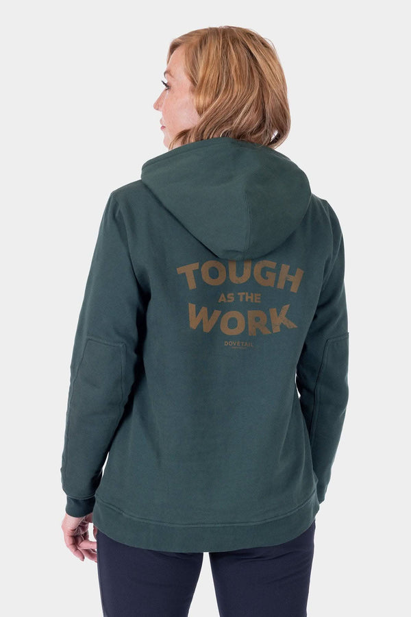 Back view of a woman wearing the Dovetail Workwear GO TO™ Graphic Hoodie in Lodge Green, featuring a graphic on the back and reinforced elbows