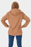Back view of a woman wearing the Dovetail Workwear GO TO™ Hoodie in Saddle Brown with navy jeans, showing the relaxed fit and front kangaroo pocket
