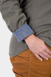 Detail of the Givens Stretch Chamois Work Shirt by Dovetail Workwear showing the Barn Red or Patina Green cuff tab and pencil pocket on the sleeve, worn with tan work pants