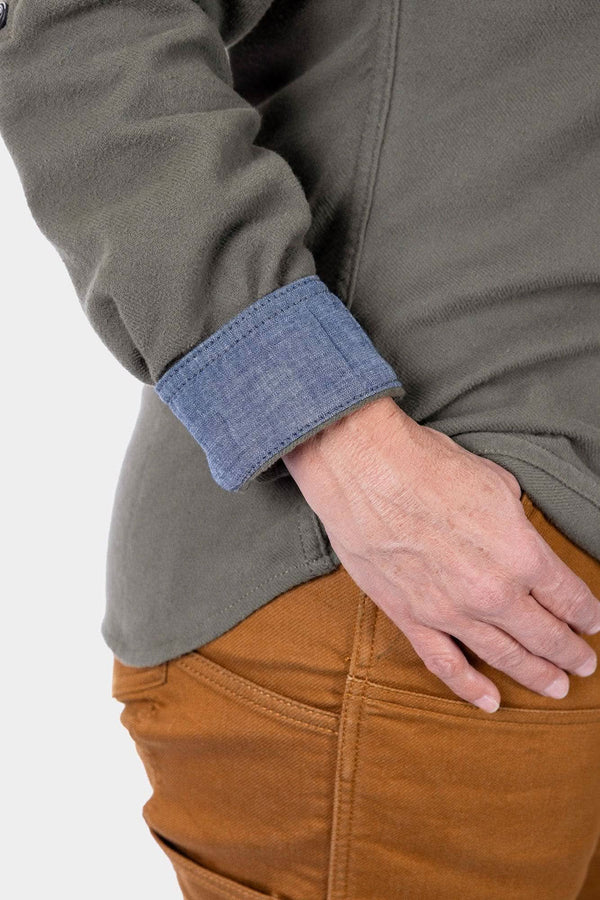 Detail of the Givens Stretch Chamois Work Shirt by Dovetail Workwear showing the Barn Red or Patina Green cuff tab and pencil pocket on the sleeve, worn with tan work pants