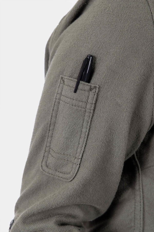 Detail view of the pencil pocket on the sleeve of the Givens Stretch Chamois Work Shirt by Dovetail Workwear, shown in Patina Green with a pen inserted