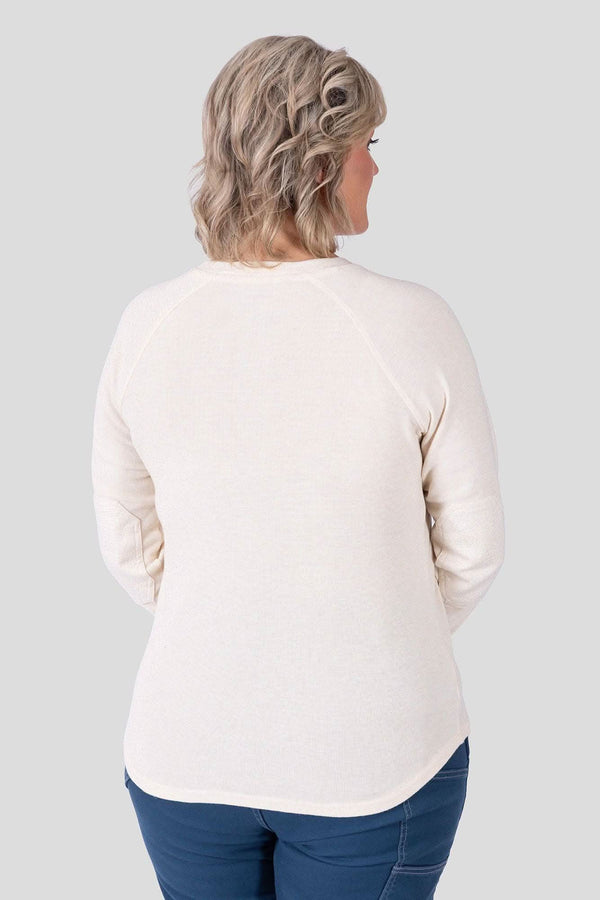 Back view of a woman wearing the Dovetail Workwear Honed Long Sleeve Thermal Henley in Oatmeal with dark jeans, showcasing the waffle knit fabric and reinforced elbows.